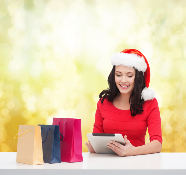 Smiling woman with shopping bags and tablet pc - Foto, afbeelding