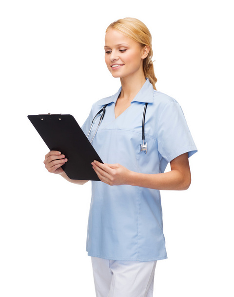 Smiling female doctor or nurse with clipboard - 写真・画像
