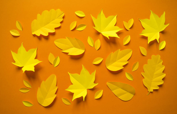 Autumn leaves made from paper on an orange background. September. October. Top view of the circle. The first of September and Halloween. - Fotografie, Obrázek