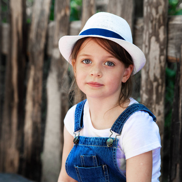 Portrait of a model girl in a denim suit and white hat - Фото, изображение