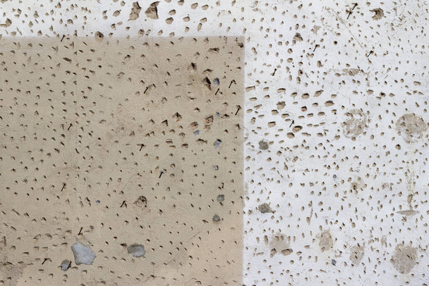 Старий цементний оштукатурений стіновий фон з гранжевою, пористою текстурою, пофарбований у два різні відтінки білого і бежевого
 - Фото, зображення