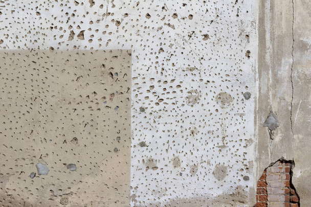 Старий цементний оштукатурений стіновий фон з гранжевою, пористою текстурою, пофарбований у два різні відтінки білого і бежевого
 - Фото, зображення