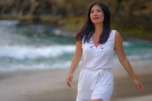 outdoors lifestyle portrait of young beautiful and happy Asian Korean woman in Summer dress enjoying cheerful walk at tropical paradise beach relaxed and blissful in holidays travel destination concept - Foto, imagen