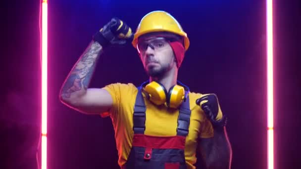 male construction worker in a hard hat dancing - Materiał filmowy, wideo