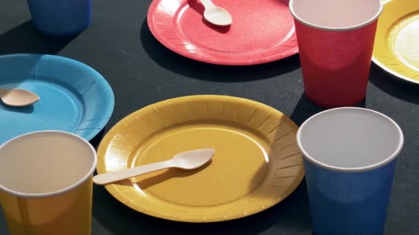 barevné talíře a sklenice na stole jsou připraveny na party - Záběry, video