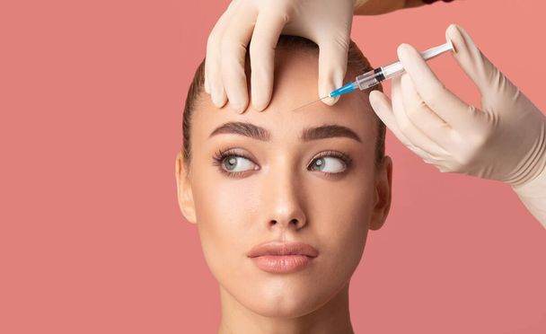 Young Woman Receiving Botox Beauty Injection In Forehead, Studio Shot - Photo, Image