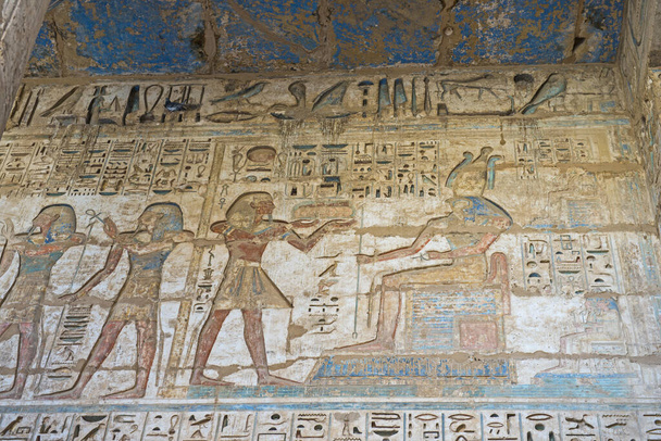 ルクソールのメディナ・ハブの古代エジプトの寺院で壁に彫刻を描いた象形文字 - 写真・画像