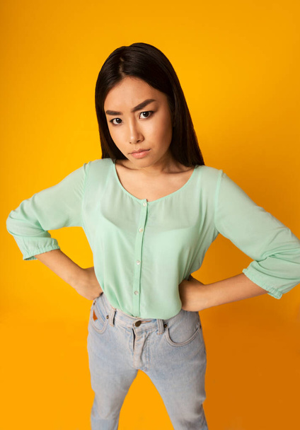 Displeased Asian Girl Posing With Hands On Hips, Yellow Background - Φωτογραφία, εικόνα
