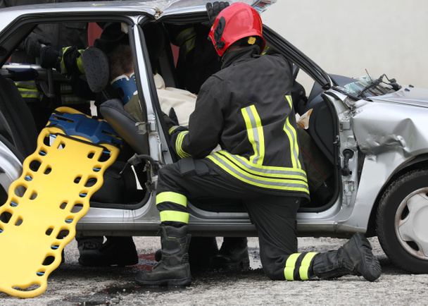 負傷者と消防士との救助のためのストレッチャーと道路事故 - 写真・画像