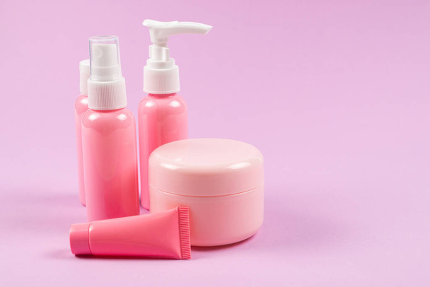 Pink plastic bottles for hygiene products, cosmetics, hygiene products on a pink background. Copy space.  - Photo, Image