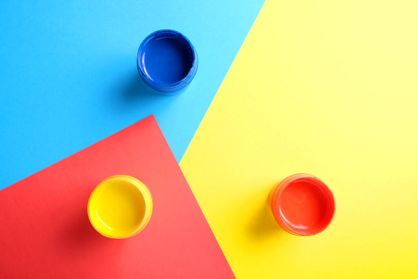 Акриловая краска в пластиковых контейнерах на цветном фоне
. - Фото, изображение