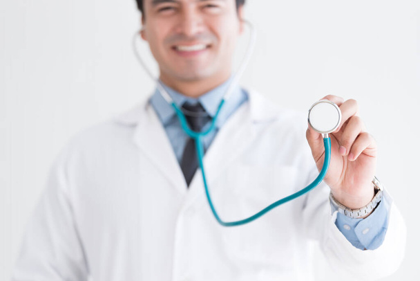 Starší izolovaný doktor drží stetoskop na bílém pozadí. - Fotografie, Obrázek