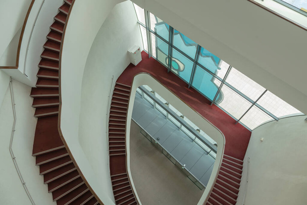 Beltéri kerek piros lépcső lefelé helyszínen, épület szerkezete - Fotó, kép