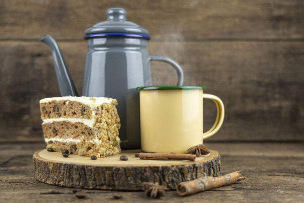 Желтая чашка горячего чая с чайником и тортом на деревянном столе
. - Фото, изображение