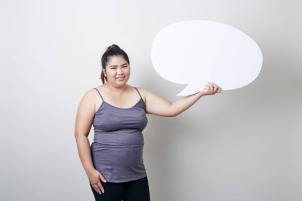 attractive young Asian  plump woman holding speech bubble empty over grey background with speech bubble chatting, space for text, Healthy exercise concept - Foto, Bild