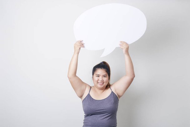 atraente jovem asiático gordo mulher segurando fala bolha vazio sobre cinza fundo com fala bolha bate-papo, espaço para texto, Saudável exercício conceito
 - Foto, Imagem