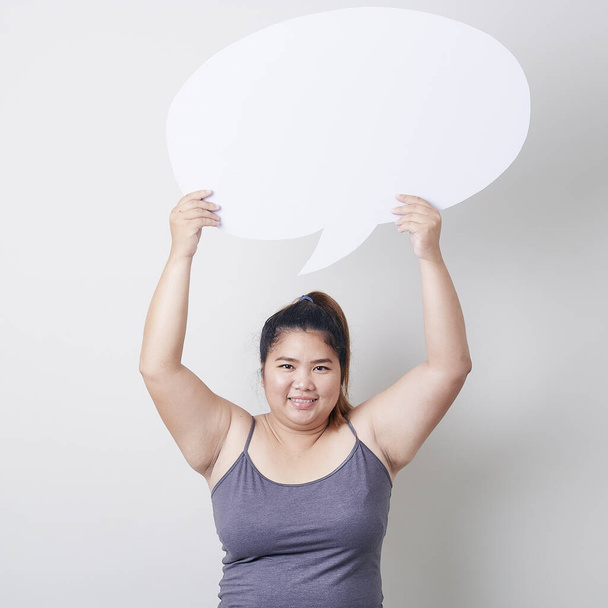 attractive young Asian  plump woman holding speech bubble empty over grey background with speech bubble chatting, space for text, Healthy exercise concept - Photo, Image