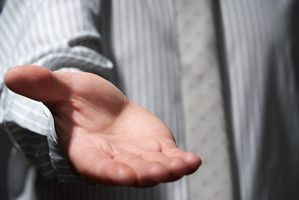 Businessman standing and showing empty palm, to get something, hand closeup. - Photo, Image