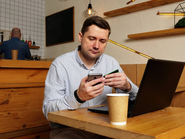 Ο άνθρωπος πληρώνει online με smartphone και πιστωτική κάρτα. - Φωτογραφία, εικόνα