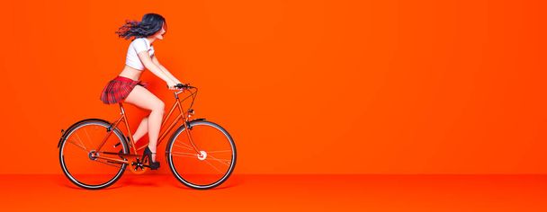 Girl skirt on bicycle.Ecological urban transport.Vintage bicycle room against wall.Studio photography.Minimal style.Copy space. 3D render bike illustration.Modern trend color 2020-Lush Lava - Fotó, kép