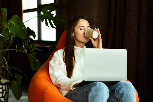 Freelance woman drinks coffee from cup in cafe - Foto, Bild
