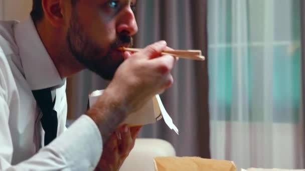Gros plan de l'homme d'affaires avec cravate manger des nouilles d'une boîte
 - Séquence, vidéo