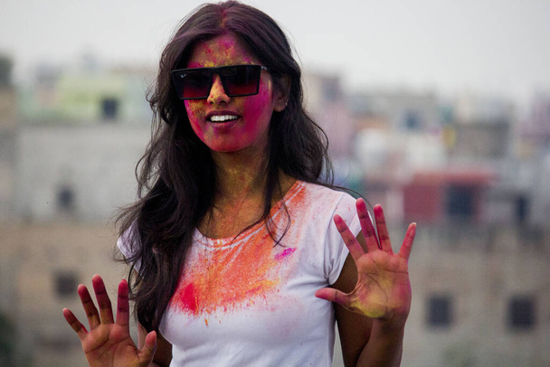 Portrait of a beautiful girl full of colored powder all over the body. Young girl plays with colors on the occasion of Holi. Concept for Indian festival Holi. Blank space available for written text. - Photo, Image