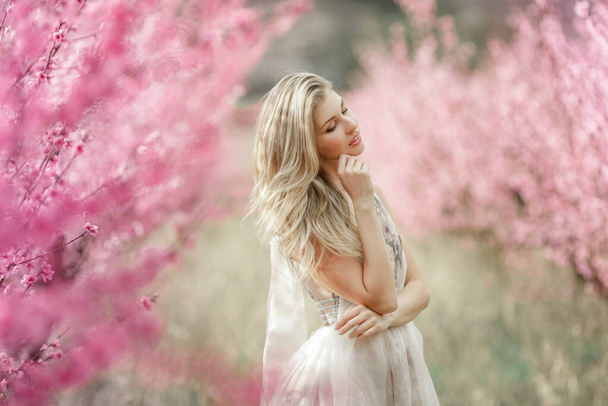 Beautiful woman dressed in a dress against the background of trees - Photo, Image