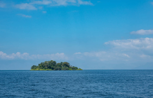 Una hermosa isla verde en las hermosas aguas tropicales azules del lago Toba en Indonesia
 - Foto, Imagen