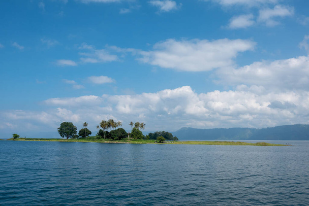Uma bela ilha verde nas belas águas tropicais azuis do Lago Toba, na Indonésia
 - Foto, Imagem