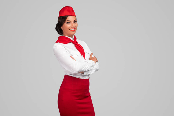 Confident adult air hostess in colorful uniform - Foto, imagen
