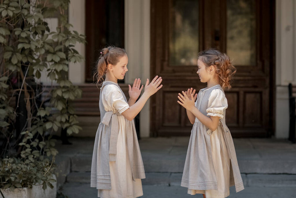 Duas meninas em roupas escolares se divertir e brincar nas ruas durante a mudança
 - Foto, Imagem
