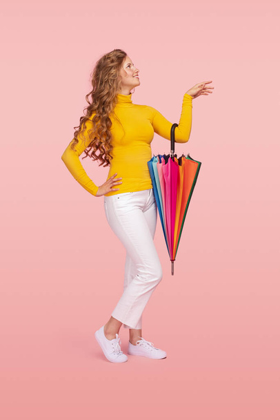 Gladful young woman in casual clothes with colorful umbrella - Foto, afbeelding