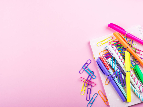Colorful stationery office supply frame on pink - 写真・画像
