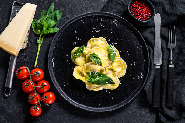 Παραδοσιακά ιταλικά ραβιόλια με τυρί και σπανάκι. Μαύρο φόντο. Άνω όψη. - Φωτογραφία, εικόνα