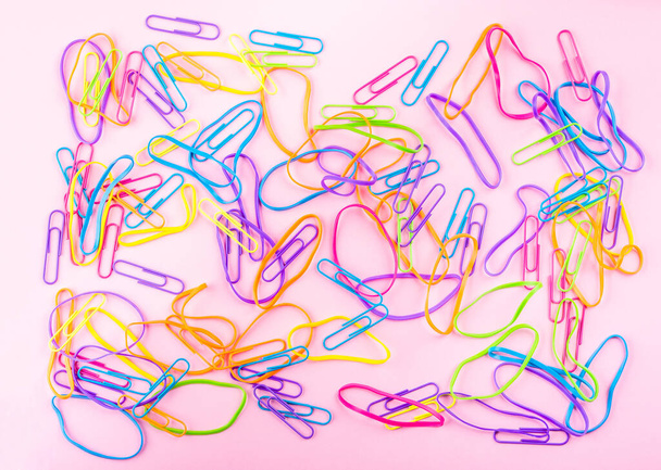 Bandas de goma de colores sobre fondo de papel rosa
 - Foto, Imagen