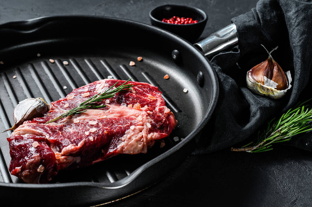 Marbled beef steak in a frying pan. Organic farm meat. Black background. - 写真・画像