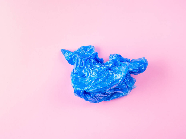 Gyűrött kék műanyag szemetes zsák rózsaszín háttér - Fotó, kép