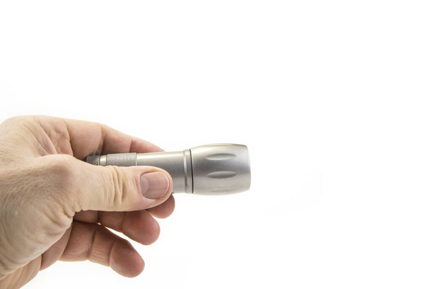 Small home pocket led flashlight in hand on the white - Fotografie, Obrázek