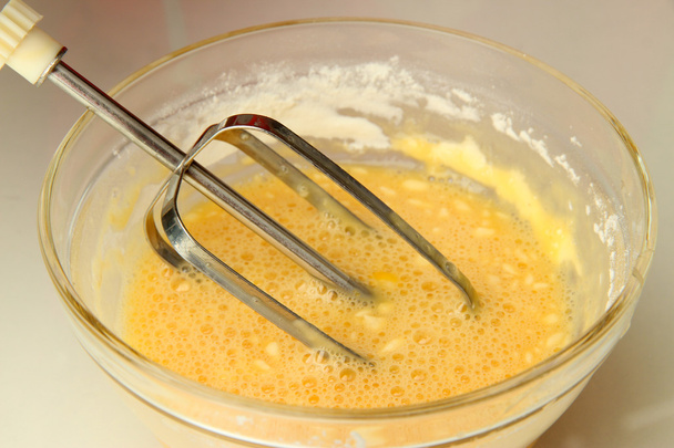 Cooking, whipping eggs with electric whisk in bowl, close up - Fotografie, Obrázek