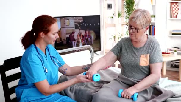 Female nurse helping old woman in nursing home - Video, Çekim