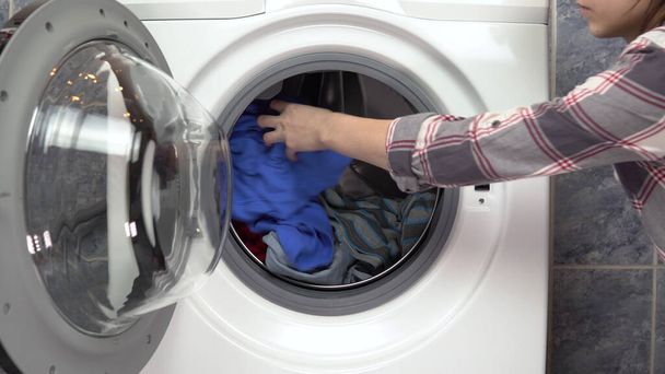 Ładowanie ubrań do pralki - Zdjęcie, obraz
