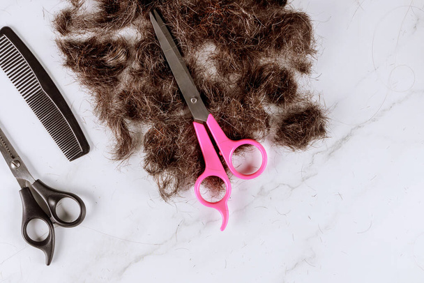 Cabello recortado de peine y pelo recortado con tijeras en una peluquería
 - Foto, Imagen