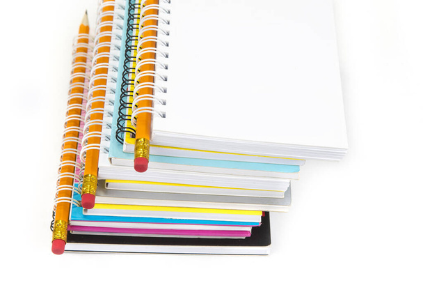 Pilha de cadernos coloridos com lápis isolados em branco
 - Foto, Imagem
