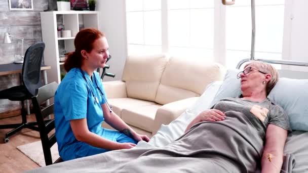 Retired old woman lying on bed in nursing home - Video, Çekim