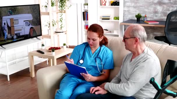 Nainen sairaanhoitaja kirjoittaa muistiinpanoja leikepöydälle
 - Materiaali, video