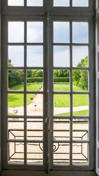 Άποψη του κανονικού Πάρκου μέσα από ένα παράθυρο με κάγκελα. Καλοκαίρι - Φωτογραφία, εικόνα