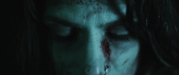 Przerażająca przerażająca zombie kobieta z zakrwawioną twarzą otwierającą białe oczy. Przerażające spojrzenie. Koncepcja transformacji kobiet w zombie. Zdjęcia w stylu horroru. Zamknij się, zwolnij tempo, kinematograficzny wygląd. BMPCC 4K - Materiał filmowy, wideo