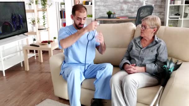 Doctor in nursing home listening old woman heartbeat - Video