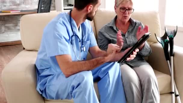 Enfermeira homem segurando tablet computador em casa de repouso
 - Filmagem, Vídeo